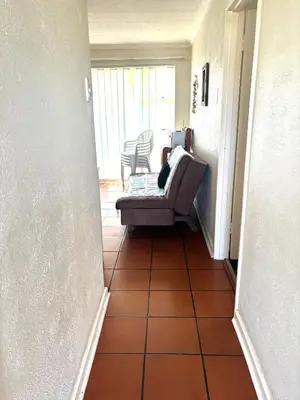 a hallway with a couch sitting on a tile floor at 111 Hermanus beach club in Hermanus