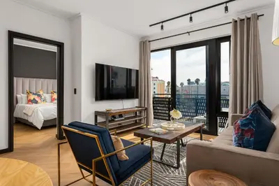 a living room with a couch and a tv at Nine Palms Stunning 1-Bedroom Apartment in Century City