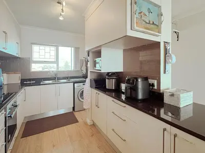 a kitchen with white cabinets and a sink at 510 Odeon Towers - SeaView in Strand