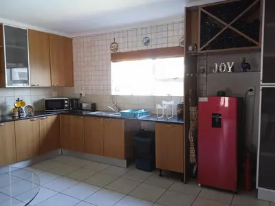 a kitchen with wooden cabinets and a red refrigerator at Carmel Huys in Cape Town