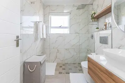 a white bathroom with a sink and a toilet at Bella View in Cape Town