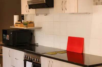 a kitchen with a counter top with a microwave at Rissie's Villa in Gordonʼs Bay