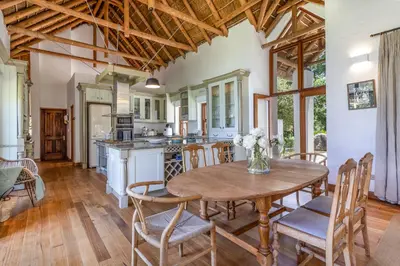 a kitchen and dining room with a wooden table and chairs at Farm House with Pool & Never Ending Mountain Views in Stellenbosch