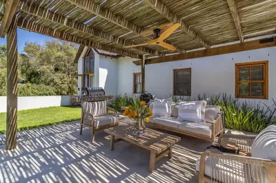 a patio with a couch and chairs and a table at Farm House with Pool & Never Ending Mountain Views in Stellenbosch