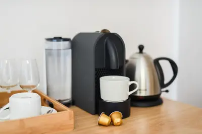 a coffee maker and cups and glasses on a table at Lovane Boutique Wine Estate and Guesthouse in Stellenbosch