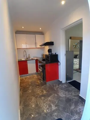 a kitchen with red and white cabinets and a counter at Livingsound 1bed self cat apartment in Cape Town