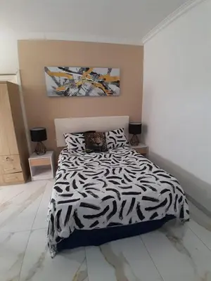 a bedroom with a zebra print bed with two tables at Livingsound 1bed self cat apartment in Cape Town