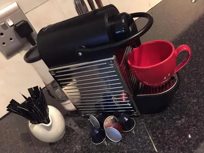 a dish drying rack with a red mug and spoons at 10 South Views in Bloubergstrand