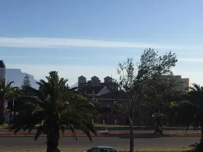 a building with palm trees in front of a street at 10 South Views in Bloubergstrand