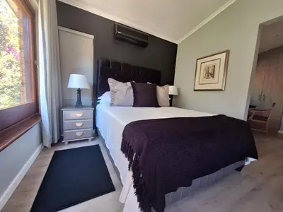 a bedroom with a large bed and a window at 41 on RUPERT in Helderberg