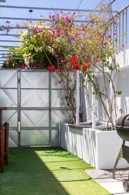 a garden with pink flowers on a fence at Villa Noor Modern 2 Bed Luxury Retreat in Hanover Park