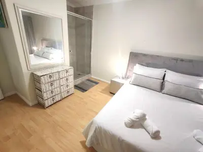 a bedroom with a white bed and a large mirror at Central, Spacious GF Apartment, access to N1,N2,M5