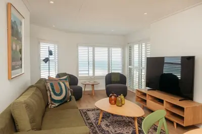 a living room with a couch and a flat screen tv at Hermanus Beach Club 218 in Hermanus