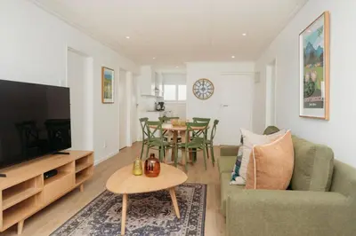 a living room with a couch and a tv and a table at Hermanus Beach Club 218 in Hermanus