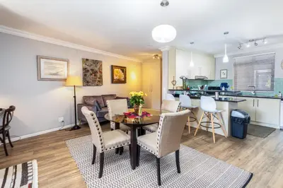 a living room and kitchen with a table and chairs at Family Oasis with Pool close to Shopping Center in Cape Town