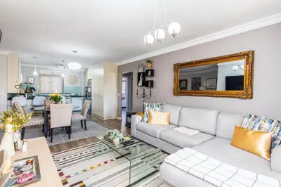 a living room with a white couch and a mirror at Family Oasis with Pool close to Shopping Center in Cape Town
