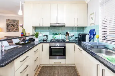 a kitchen with white cabinets and a sink at Family Oasis with Pool close to Shopping Center in Cape Town