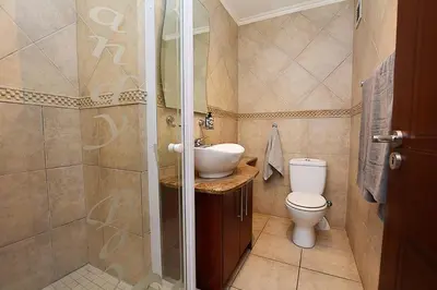 a bathroom with a toilet and a sink and a shower at 3B Sandy Bay in Cape Town