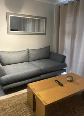a living room with a couch and a coffee table at 3B Sandy Bay in Cape Town