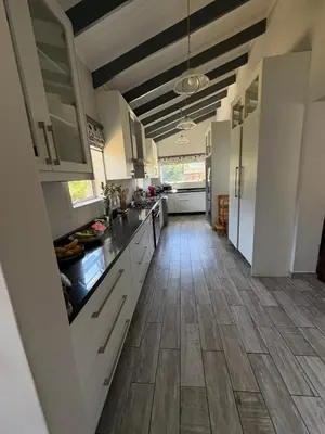 a large kitchen with white cabinets and a wooden floor at North of the vines in Oakdale