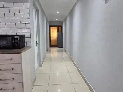 a hallway leading to a kitchen with a microwave at Maglovir economy 3 BEDROOMS BULK in Tiervlei