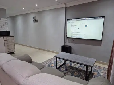a living room with a couch and a projection screen at Maglovir economy 3 BEDROOMS BULK in Tiervlei