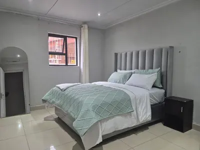 a bedroom with a large bed and a window at Maglovir economy 3 BEDROOMS BULK in Tiervlei