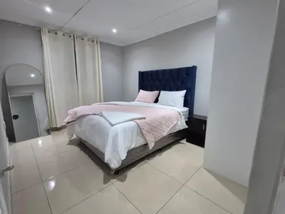 a bedroom with a bed with a blue headboard at Maglovir economy 3 BEDROOMS BULK in Tiervlei