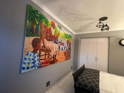 a bedroom with a large painting on the wall at Beach Walk Guest House & Apartments in Cape Town