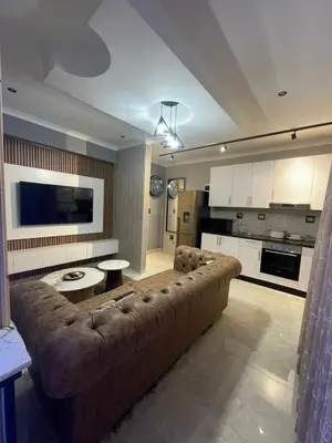 a living room with a large couch and a kitchen at Beach Walk Guest House & Apartments in Cape Town