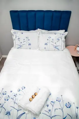 a bed with a blue headboard with two donuts on it at Divine Favor House on 44 Torrington in Cape Town