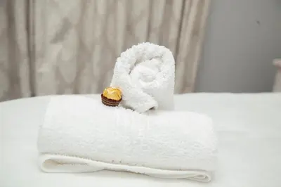 a pile of towels with a cookie on top of it at Divine Favor House on 44 Torrington in Cape Town