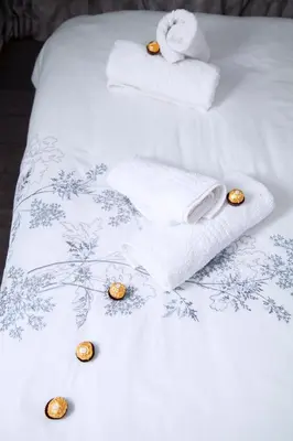 two beds with towels and spa items on them at Divine Favor House on 44 Torrington in Cape Town