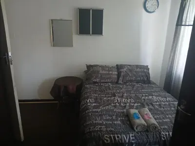 a bedroom with a bed with a dog sitting on it at Braai and chill getaway in Goodwood