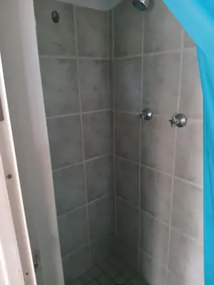 a bathroom with a shower with gray tile at Braai and chill getaway in Goodwood