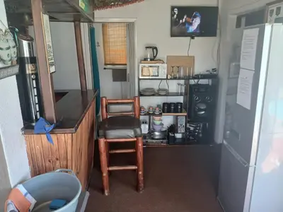 a kitchen with a refrigerator and a table and a chair at Braai and chill getaway in Goodwood