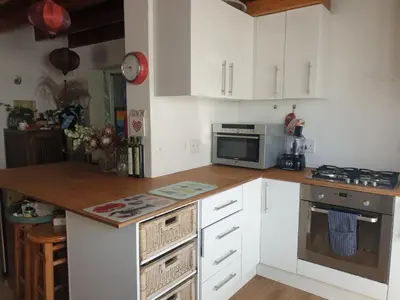 a kitchen with white cabinets and a counter top at Cozy family home in Cape Town