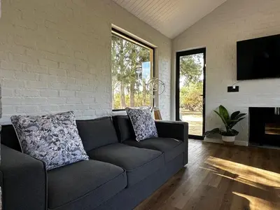 a living room with a couch and a tv at Genadendaal Vineyard Villa in Paarl