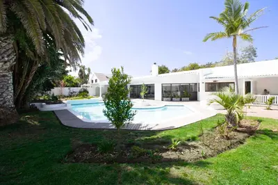 an exterior view of a house with a swimming pool at Northcliff House in Hermanus