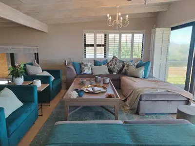 a living room with blue couches and a table at Paradise Piet Haven in Hermanus