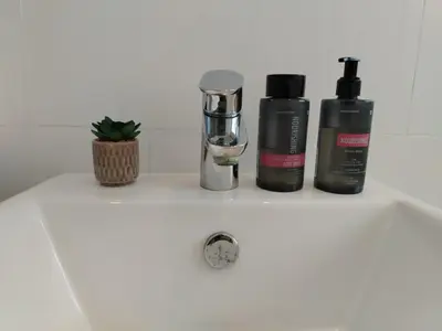 a bathroom sink with three products on it at Paradise Piet Haven in Hermanus