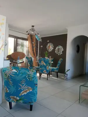 a living room with blue chairs and a table at Carol's Place in Somerset West