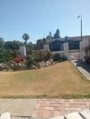 a backyard with a fence and a yard with grass at Carol's Place in Somerset West