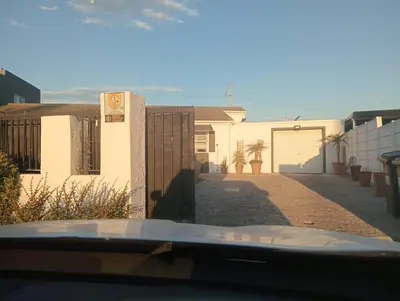 a view of a house with a fence and a garage at Carol's Place in Somerset West