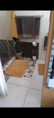 a bathroom with two mats on a tile floor at Carol's Place in Somerset West