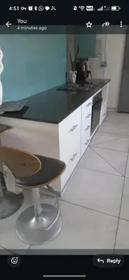 a kitchen with a black counter top and a stool at Carol's Place in Somerset West