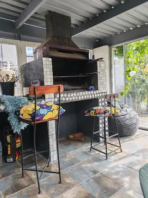 a patio with two chairs and an outdoor oven at Carol's Place in Somerset West