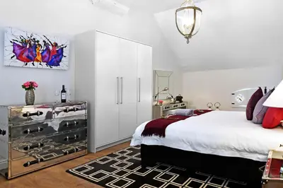 a bedroom with a bed and a dresser with shoes at La Providence in Franschhoek