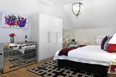 a bedroom with a bed and a dresser with shoes at La Providence in Franschhoek
