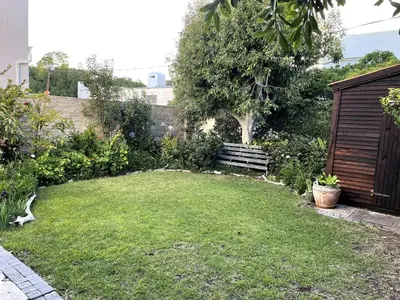 a small garden with a lawn and a fence at Secret Coastal Garden in Hermanus